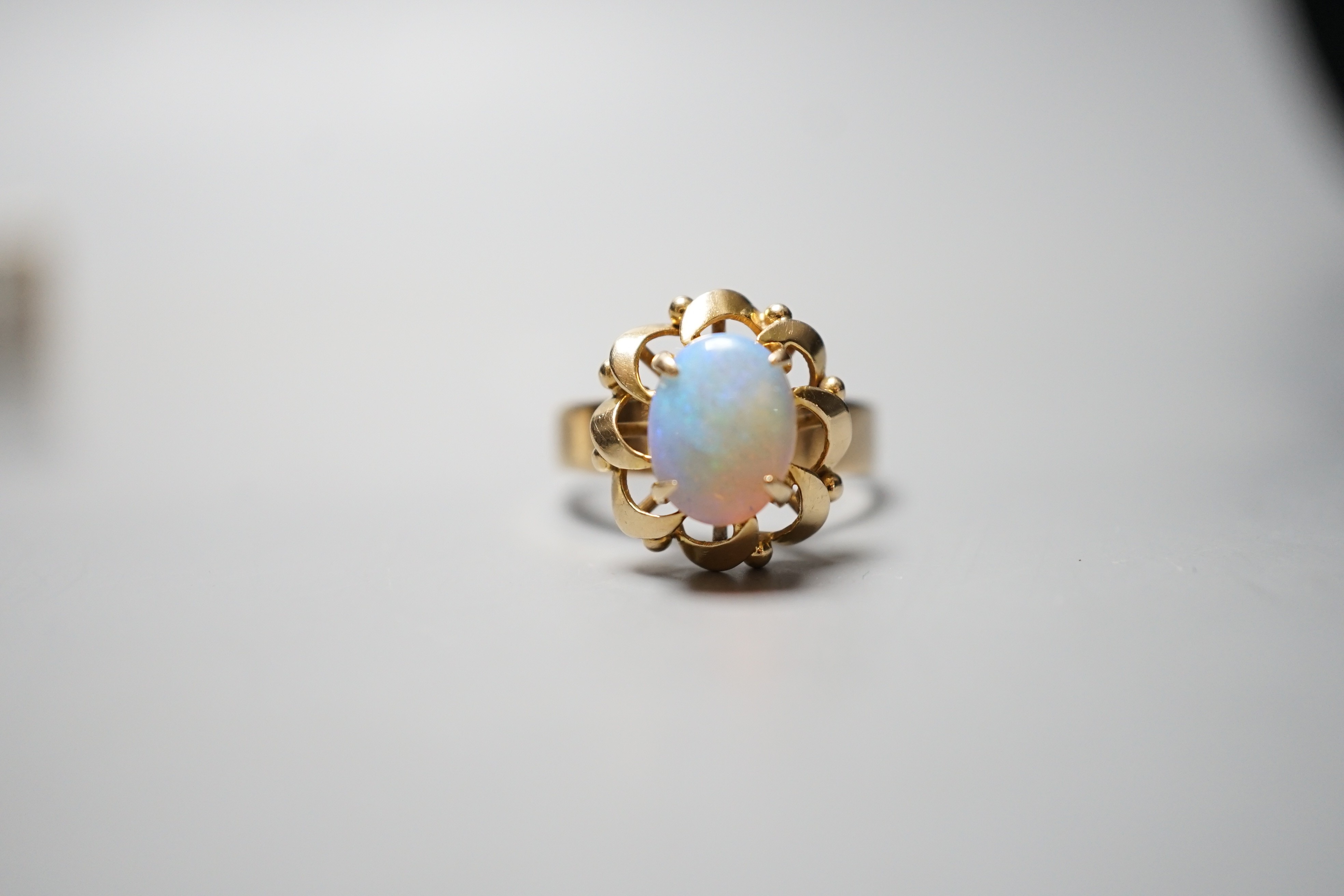 A 14k yellow metal and white opal set oval dress ring, size O, gross weight 3.9 grams.